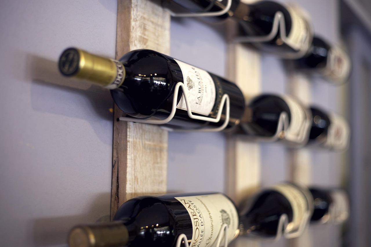 Prateleira de madeira com garrafas de vinho armazenadas para envelhecimento