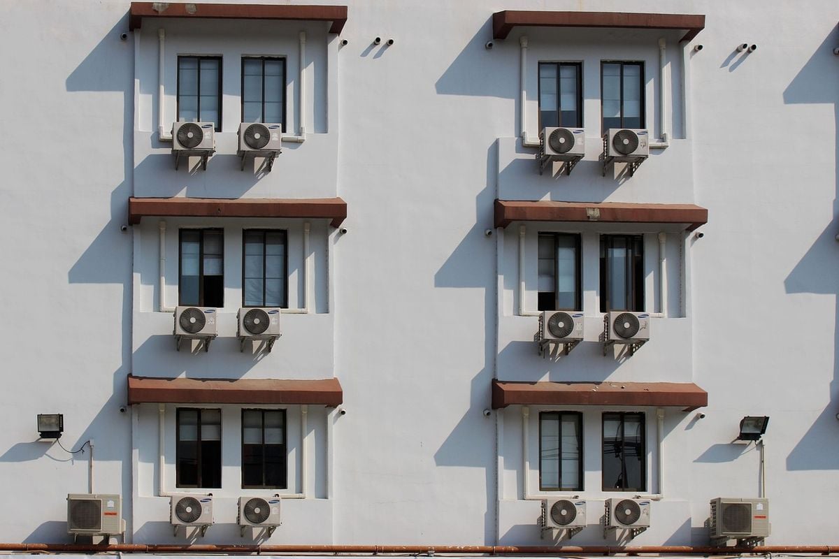 Prédio com aparelhos de ar-condicionado instalados Fachada com vários aparelhos de ar-condicionado nas janelas