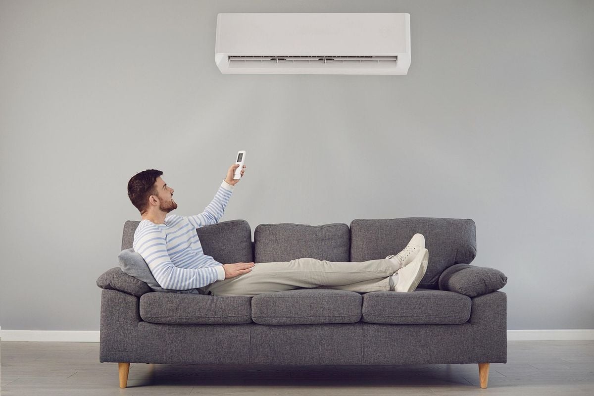 Conforto térmico em ambiente climatizado por ar-condicionado Pessoa relaxando em sala climatizada com ar-condicionado