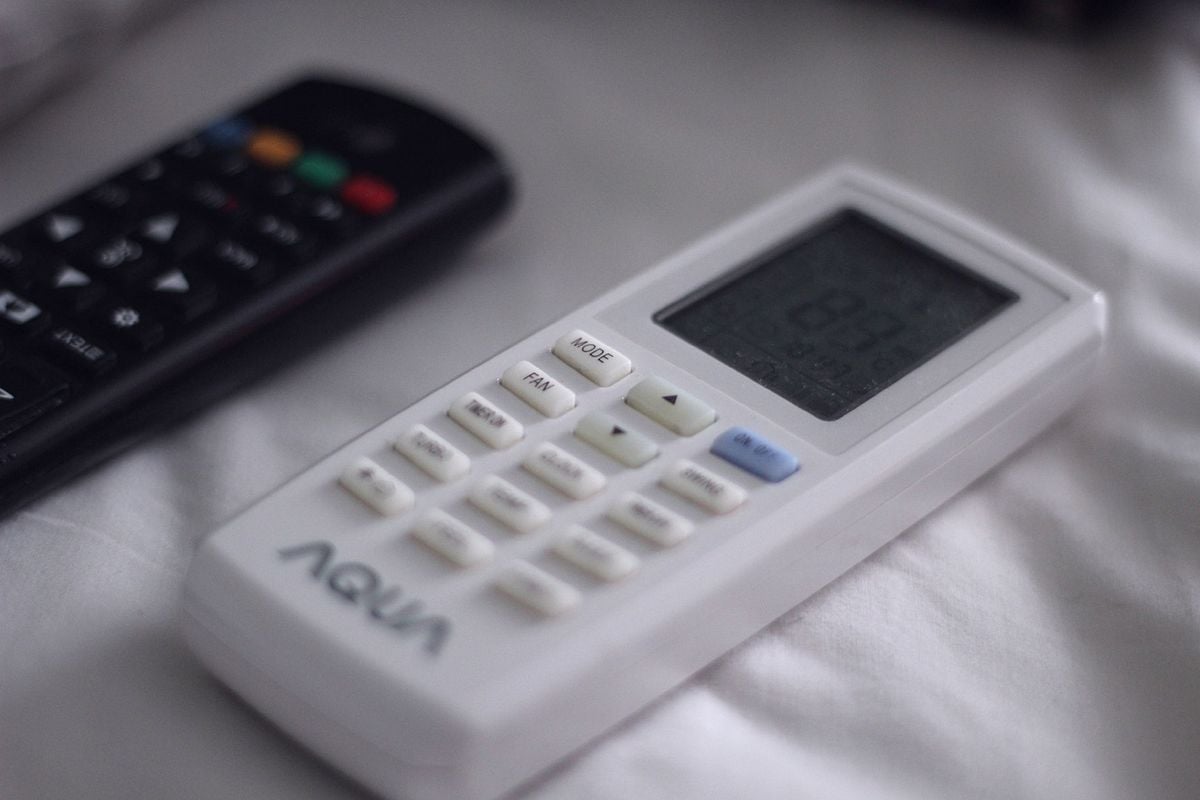 Ajustar a temperatura entre 23°C e 25°C é uma das formas mais simples de economizar Controle remoto de ar-condicionado com display digital de temperatura