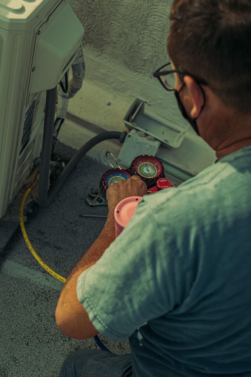 Técnico usando manômetros na instalação do ar-condicionado Técnico instalando a unidade externa de um ar-condicionado
