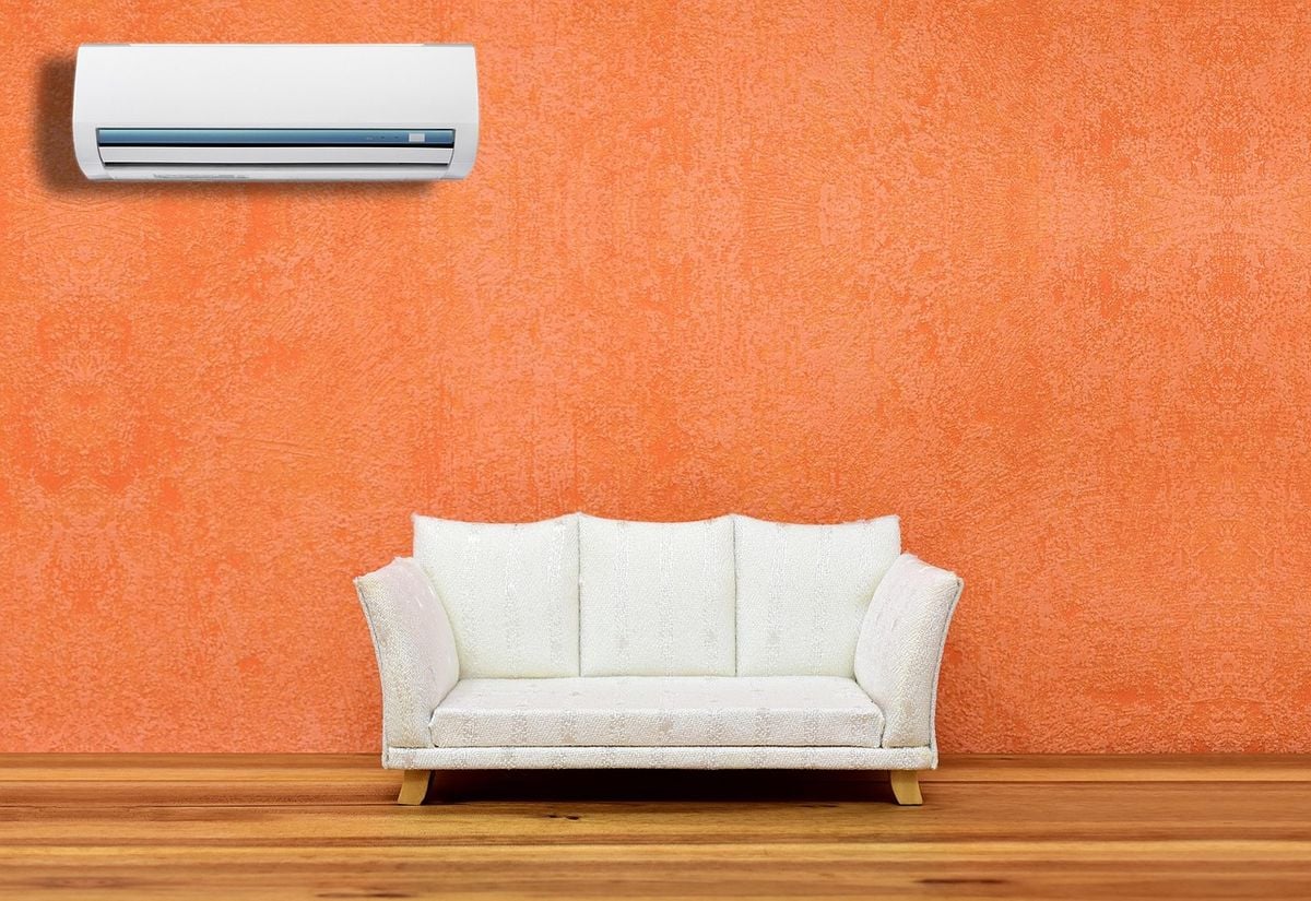 Sala de casa com ar-condicionado split hi wall instalado na parede acima do sofá