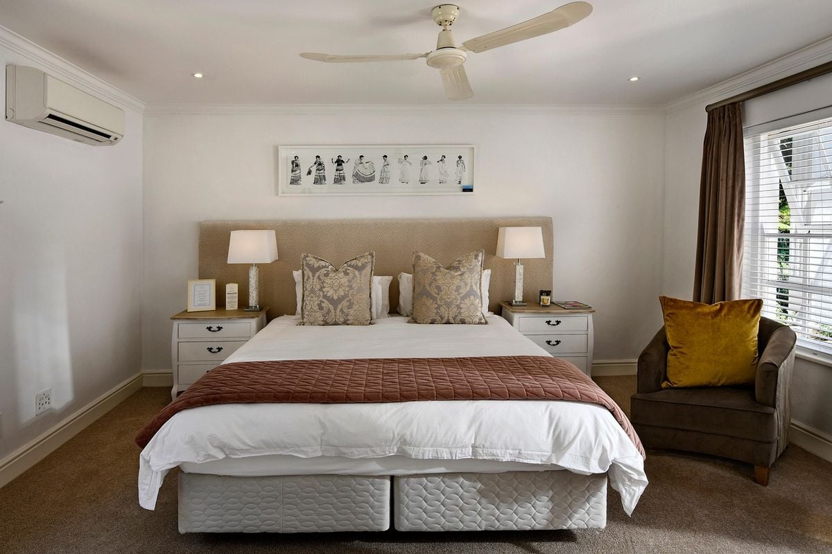 Quarto de casal com ar-condicionado split instalado na parede acima da cabeceira