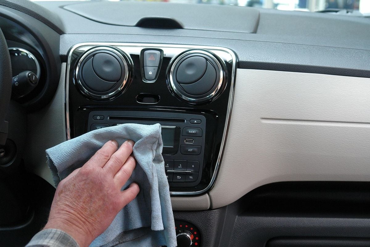 Limpeza do painel do carro com pano de microfibra Pessoa limpando o painel do carro com pano de microfibra